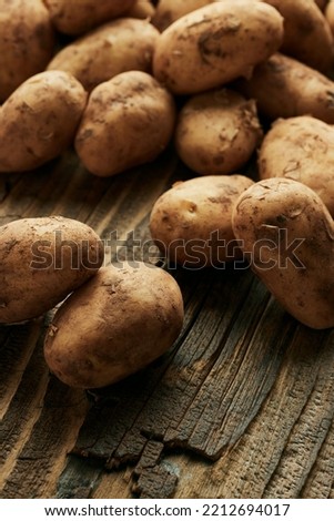 Potatoes over wooden background. Vintage food still life