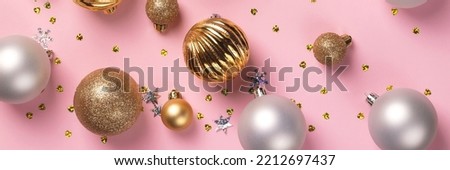 Christmas card with golden and silver balls and confetti on pink background banner. Wide panoramic header