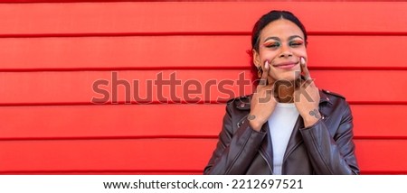 smiling girl with hands up on the street on red background