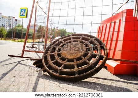 Open sewer hatch. Construction and repair of heating mains in the city. Rusty equipment of heating networks and sewers. Close-up