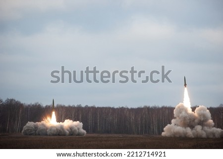 Launch of military missiles (rocket artillery) at the firing field during military exercise Royalty-Free Stock Photo #2212714921