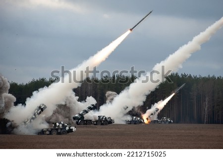 Launch of military missiles (rocket artillery) at the firing field during military exercise Royalty-Free Stock Photo #2212715025