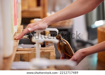 Close Up Of Woman Refilling Glass Bottle With Liquid Soap In Sustainable Zero Waste Plastic Free Store Royalty-Free Stock Photo #2212717489