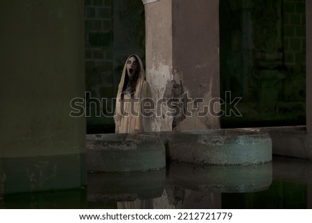 Urban ghost "Llorona" next to a water tank Royalty-Free Stock Photo #2212721779
