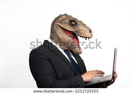 businessman with tyrannosaurus rex head using his laptop on white background