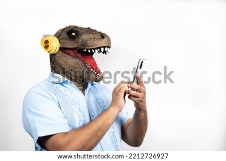 Euphoric man with T- rex head with smartphone listening music