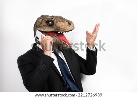 executive man with T rex mask talking on the phone on an isolated white background