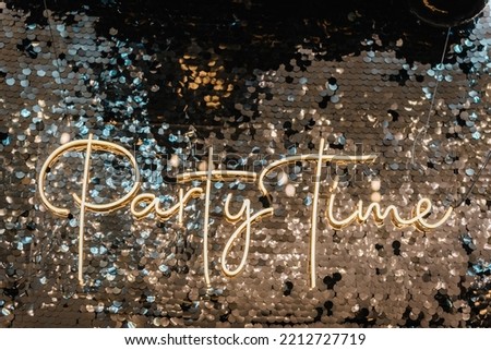 Happy New Year 2023. Silver photo booth with decor shiny and led strips with text party time. Zone with sparkling sequins. Light blur background for wedding. A place for congratulations for birthday.