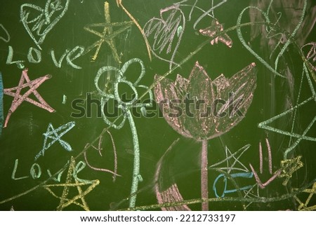 Drawings of children with chalk on a school green board.