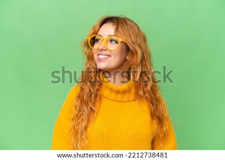 Young caucasian woman isolated on green screen chroma key background With glasses with happy expression