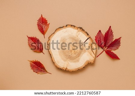 Wooden aesthetic podium with autumn red leaves top view, brown background