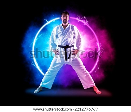 Karate masters in white kimono with black belt on neon background