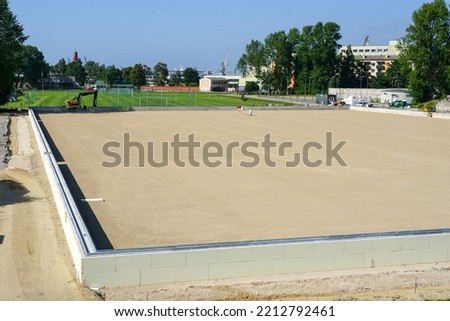 prepared base and concrete border for installation of inflatable playing arena, football hall, air dome on blue sky background Royalty-Free Stock Photo #2212792461