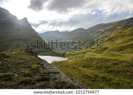 Panoramic summer view of Bachalpsee lake with Schreckhorn and Wetterhorn peaks on background. Gloomy outdoor scene of Swiss Bernese Alps, Switzerland, Europe.
