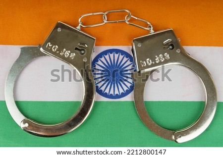 The concept of law and crime. There are handcuffs on the flag of India.