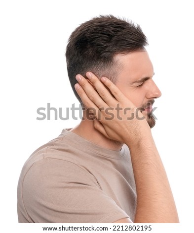 Young man suffering from ear pain on white background Royalty-Free Stock Photo #2212802195