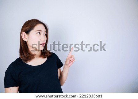 Japanese woman pointing at blank space on white background