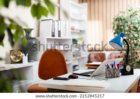 Comfortable workplace desk for businessman with laptop in white modern office interior
