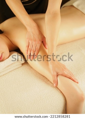 Asian female esthetician massaging her arm Royalty-Free Stock Photo #2212858281