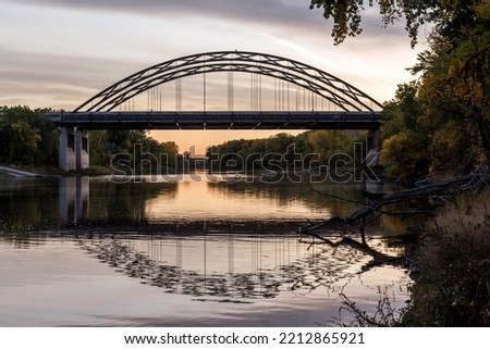 A Medium Shot of the MN-77 or Cedar Avenue Bridge Reflecting in the Minnesota River during an Autumn Golden Hour Royalty-Free Stock Photo #2212865921