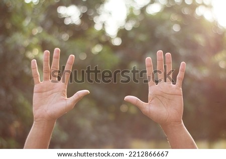 fingers showing numbers or signs, in the background bokeh