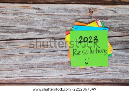 New year 2023 goals, resolutions and bucket list concept. Colorful sticky notes on wood background.