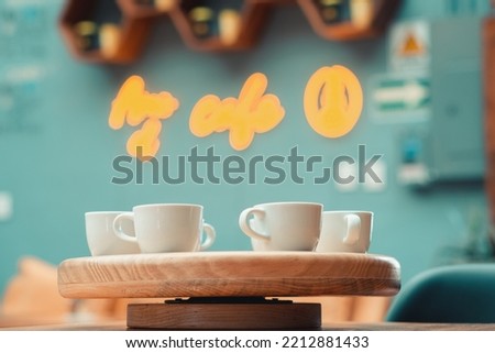 Several cups of coffee, in the background a neon sign.
