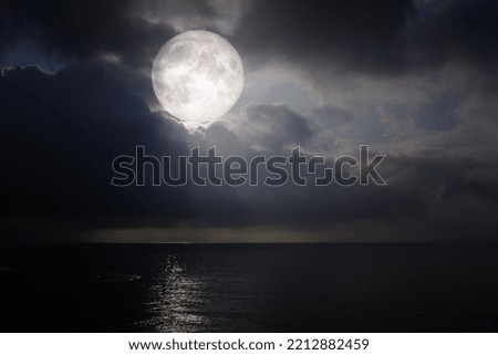 Landscape moon over the horizon on sea and moonlight. Panorama with the luna of night. Grand mystical fantastic view. Mid-Autumn Festival or Halloween concept. The full moon was furnished by NASA.