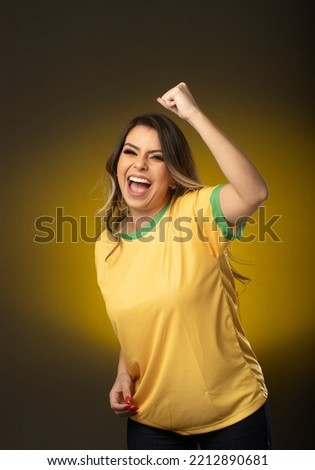 Brazilian fan. Brazilian woman fan celebrating in soccer or soccer match on yellow background. Brazil colors