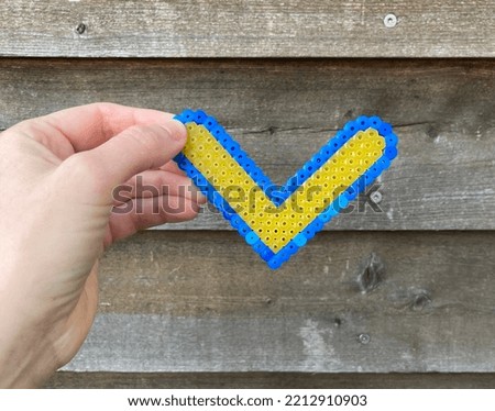 Pearl heart in Ukraine colors on wooden background
