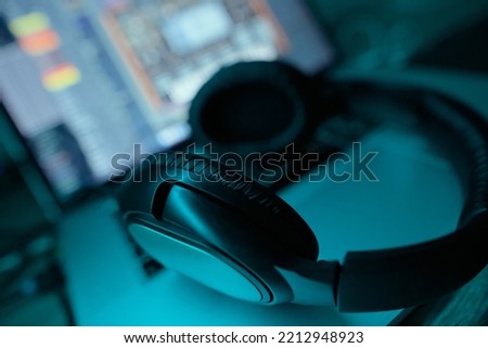 Headphones on a table in neon near a laptop close-up. Sounddesign.
