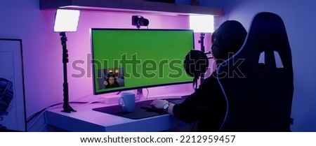 GREEN SCREEN CHORMA KEY Korean female gamer streamer putting on headphones, playing online games and streaming from home
