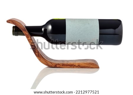 Bottle of red wine in a wooden bottle holder is isolated on a white background. On a bottle empty label.