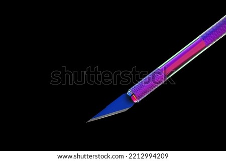 metal scalpel illuminated in different colors. black background close-up