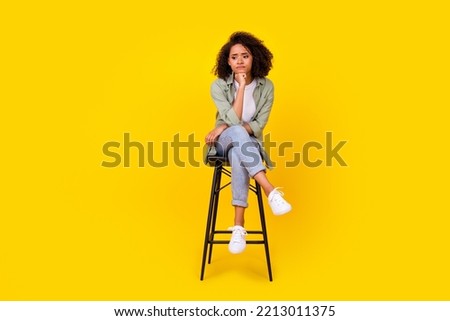 Full length photo of attractive young lady curly hair sit chair sad unsatisfied wear trendy khaki look isolated on yellow color background Royalty-Free Stock Photo #2213011375