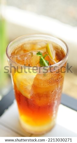 close-up a glass of ice tea with mint and lemon on table