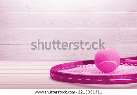 Classic tennis racket with a ball in pink color