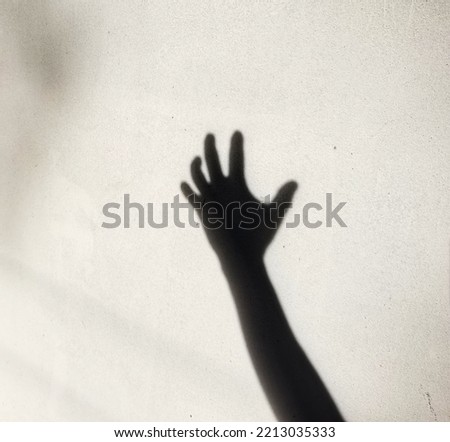 black hand shadow on concrete wall