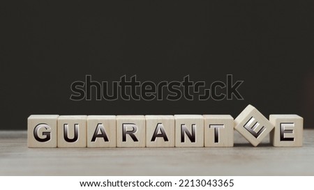 Text GUARANTEE on wood cube block, stock investment concept. The text GUARANTEE is written on the cubes in black letters