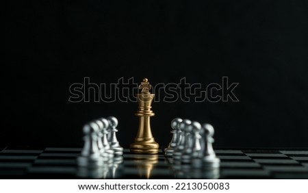 Leadership. gold queen with silver chess pieces on chess board game competition on dark background, chess battle, 
team leader, teamwork and business strategy concept,victory, success, management
