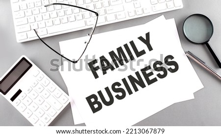 FAMILY BUSINESS text on a paper with keyboard, calculator on grey background