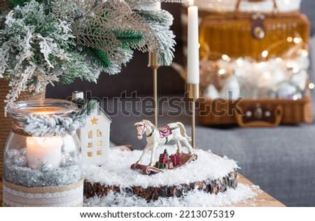 Happy New Year 2023. A Christmas card, a banner with a rocking horse, Christmas trees, gifts and a beautiful bokeh in the background. The concept of home winter holidays, warmth and comfort.