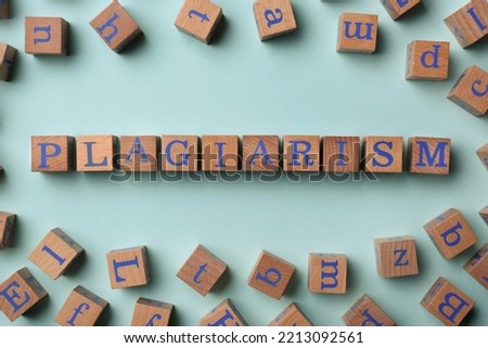 Wooden cubes with word Plagiarism on turquoise background, flat lay Royalty-Free Stock Photo #2213092561