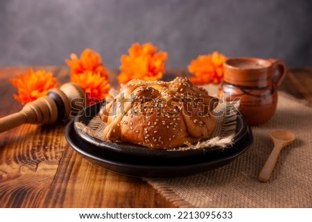 Pan de Muerto. Typical Mexican sweet bread with sesame seeds, that is consumed in the season of the day of the dead. It is a main element in the altars and offerings in the festivity Royalty-Free Stock Photo #2213095633