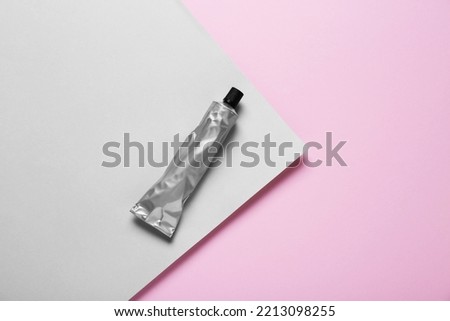 Tube of glue on color background, top view. Space for text