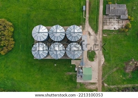 Agricultural silos on the farm in autumn, close-up drone view. Industrial granary, elevator dryer, building exterior, storage and drying of grain, wheat, corn, soy, sunflower. Europe in Hungary