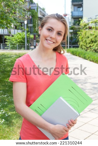 Laughing female student in a red shirt on campus