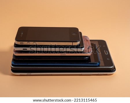 Old broken smartphones. Smartphones on an orange background. Close-up.