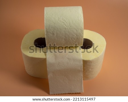 Roll of Toilet paper on an orange background. Close-up.