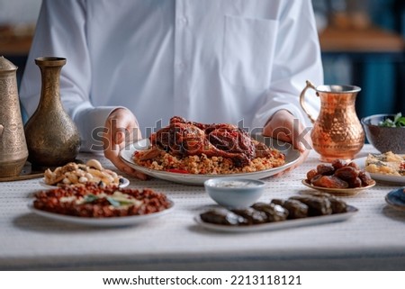 Kabsa, hummus, maqluba, maqluba, tabbouleh close-up, rice and meat dish, middle eastern national traditional food. Muslim family dinner, Ramadan, iftar. Arabian cuisine. Royalty-Free Stock Photo #2213118121